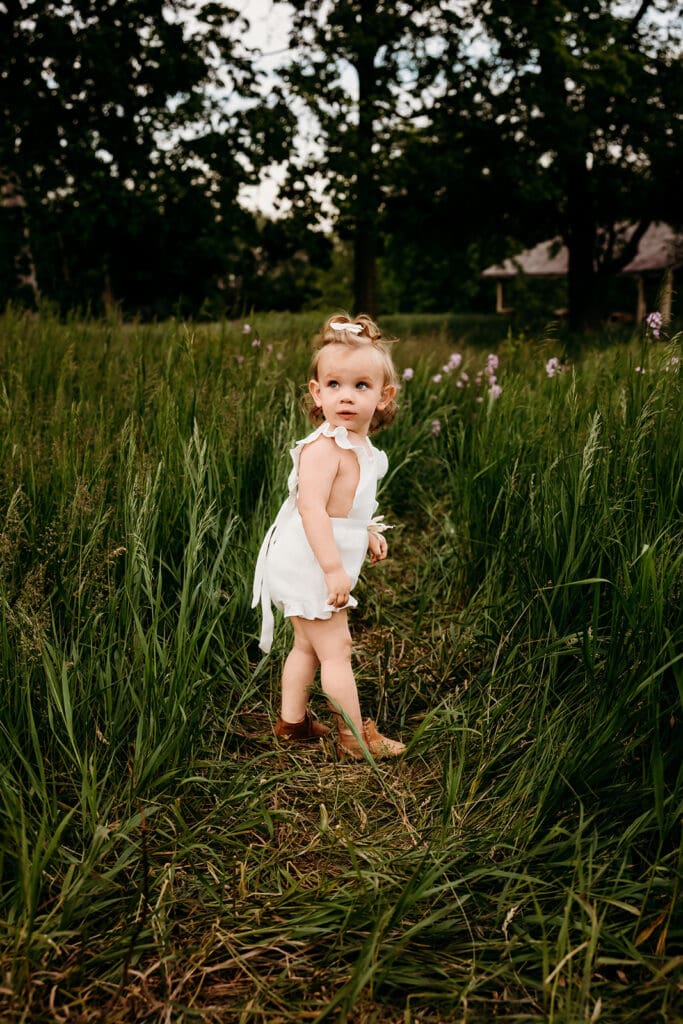 Candid image of toddler beginning to smile after a tough moment during family photo session