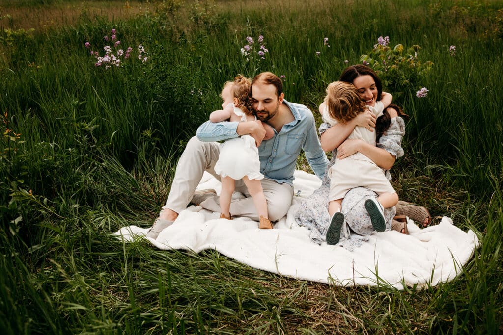 family hugging in the middle of wildflowers during an emotional naperville family session