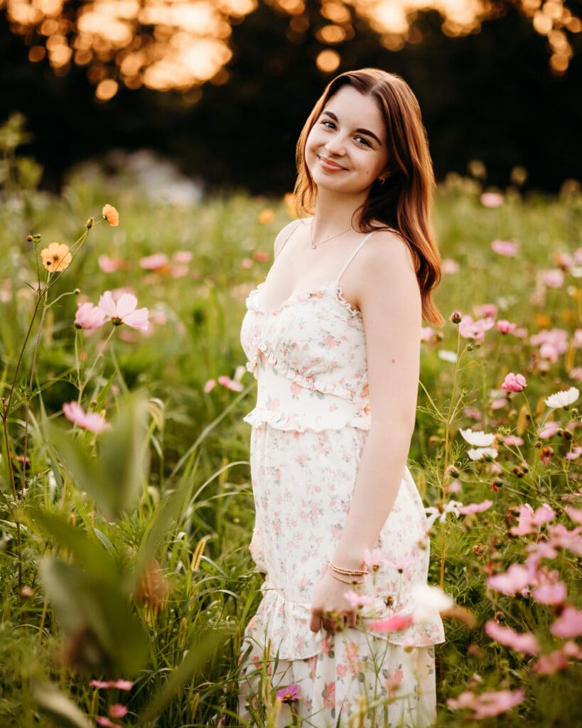 A senior girl smiling in a wildflower field during a photography session in the chicago suburbs.