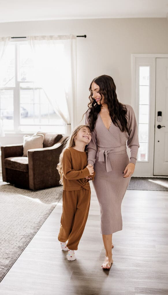 Mother and daughter sharing a tender moment on the staircase during an in-home family lifestyle session in Oswego IL