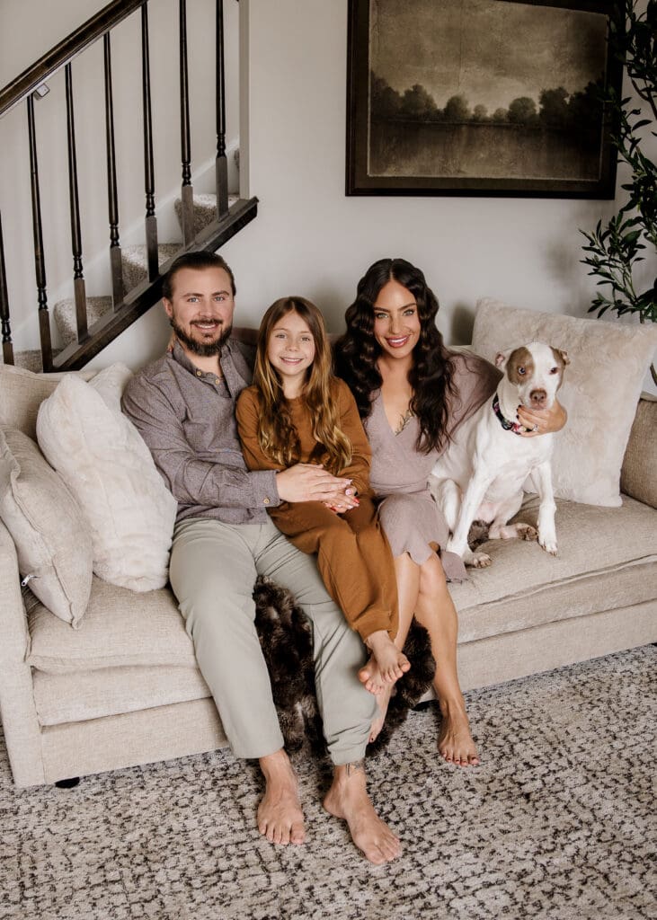 Whole family smiling on couch in Naperville, IL during a lifestyle family photography session.